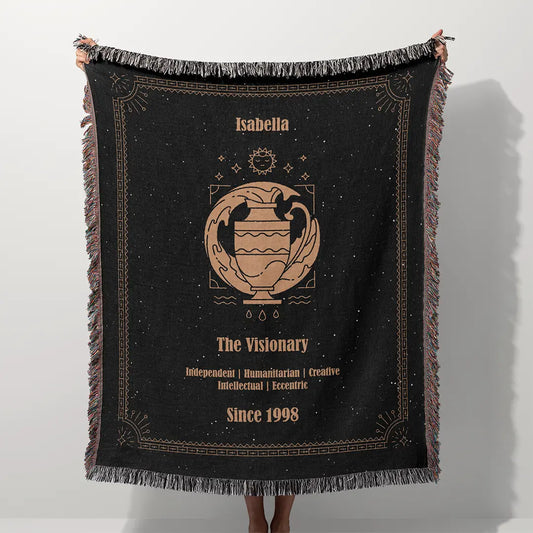 A custom blanket featuring an Aquarius zodiac design held up on a white background, showcasing a personalized name, date, and traits.