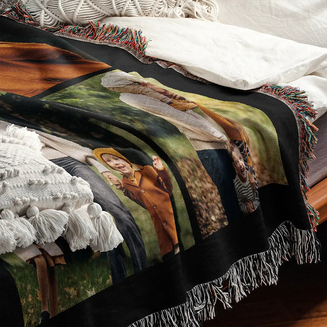 Custom woven photo blanket with fringed edges displayed on a bed with textured pillows.