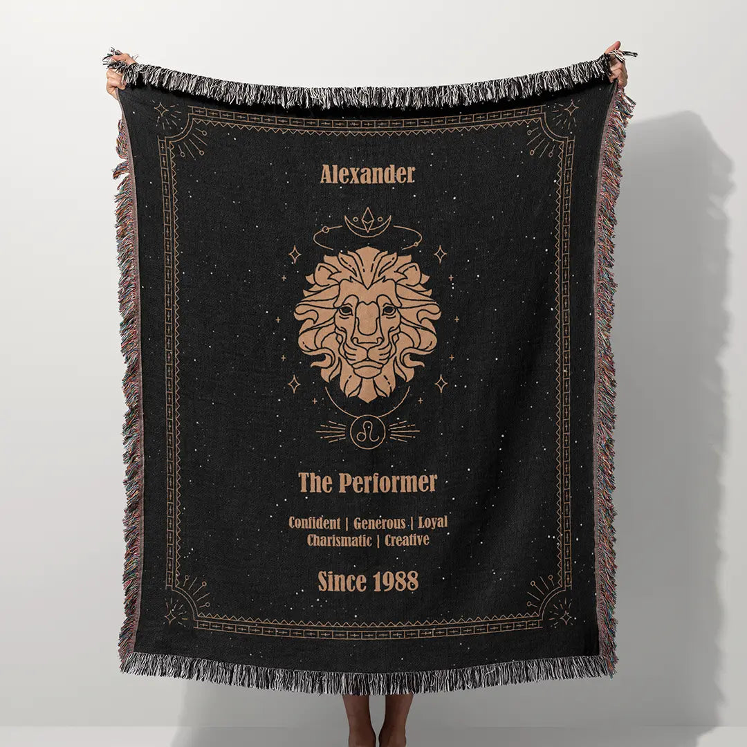 A custom blanket featuring a Leo zodiac design held up on a white background, showcasing a personalized name, date, and traits.