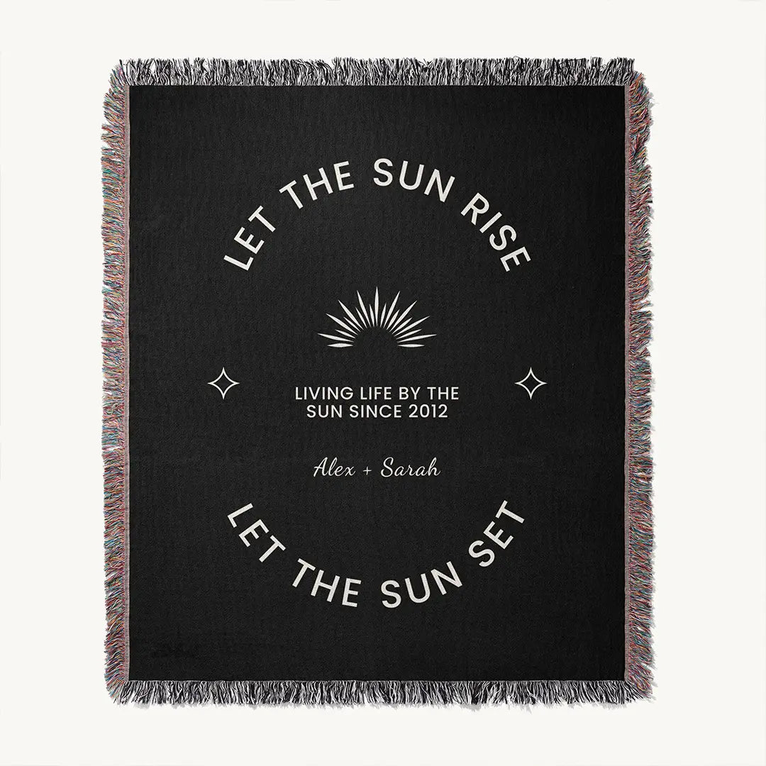 Full view of custom woven cotton name blanket for couples, with white celestial accents and sun design woven into a black cotton background and custom names.