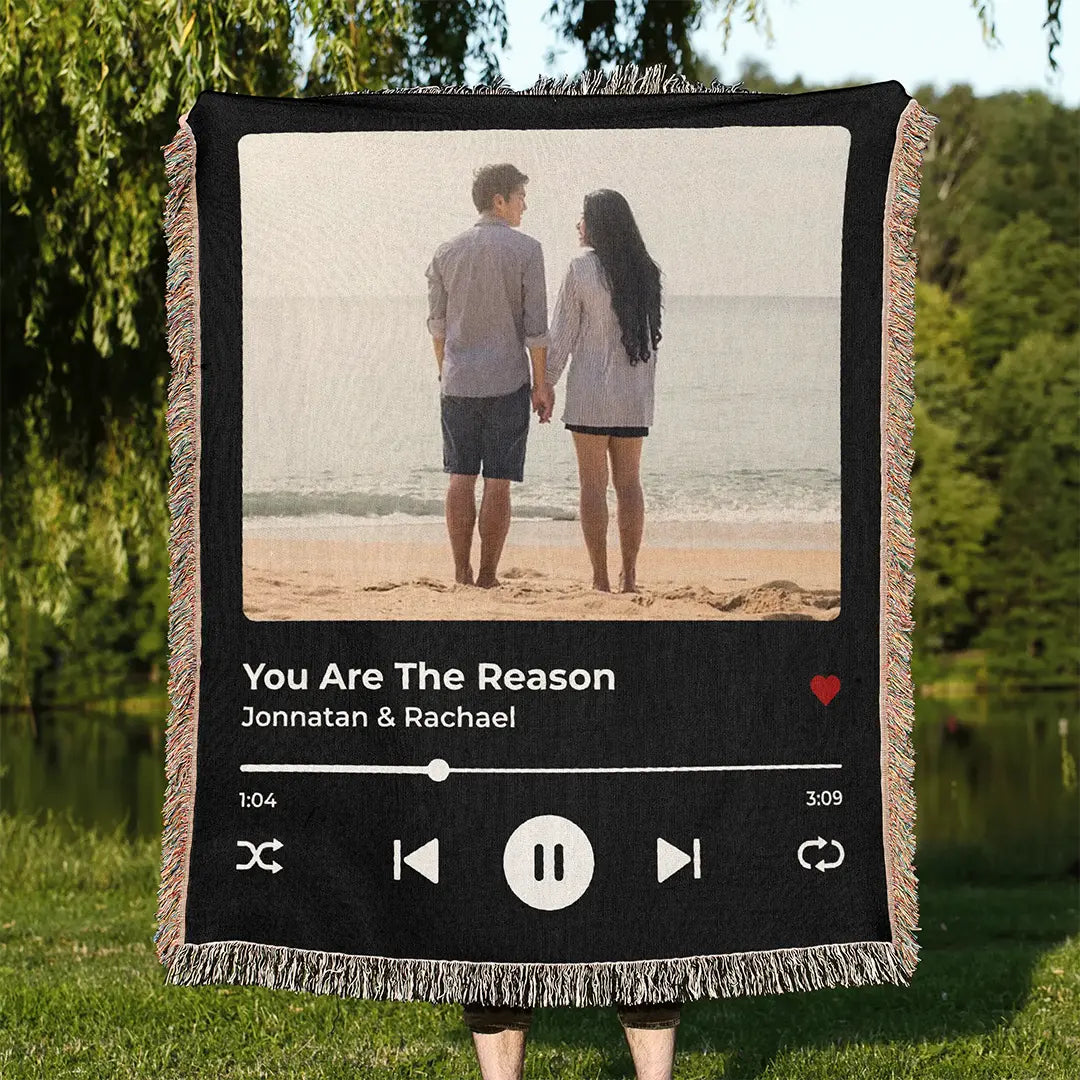Personalized music player woven cotton blanket for couples, displayed outdoors, held up by a person in a natural green park setting.