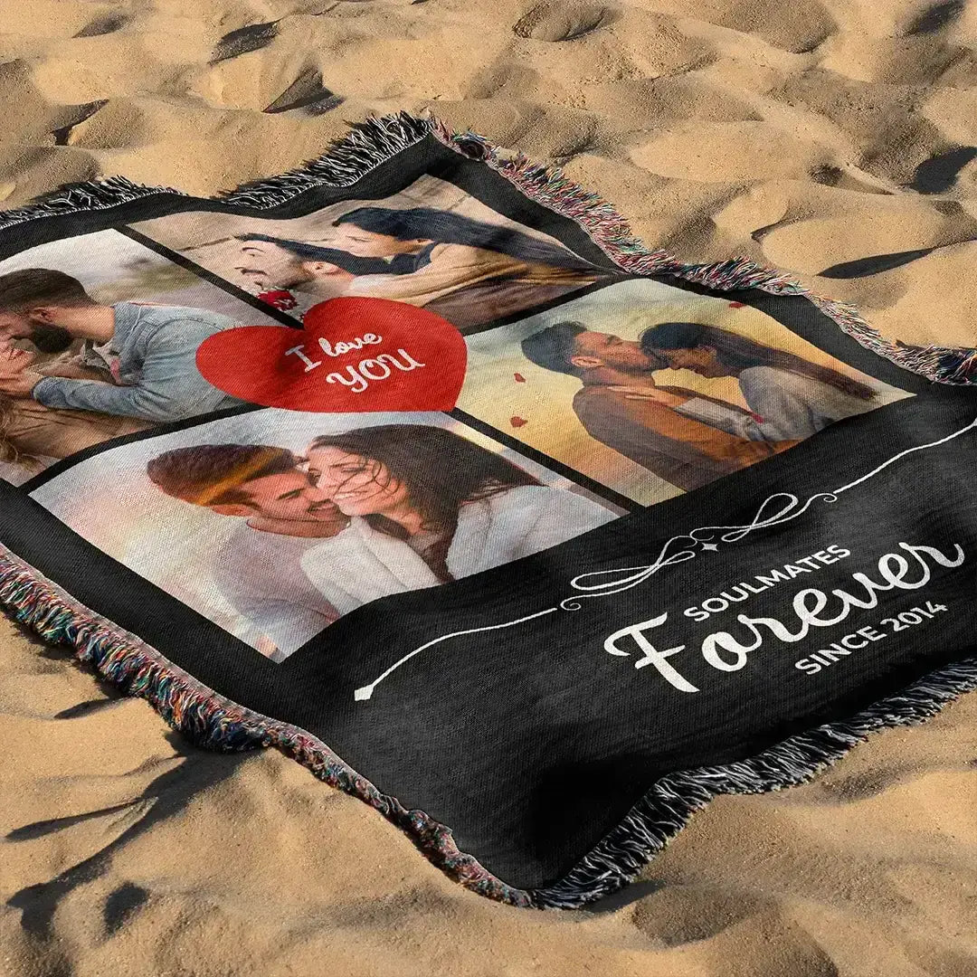 Personalized black woven photo cotton blanket for couples with fringed edges laid on sand, photographed in natural daylight.