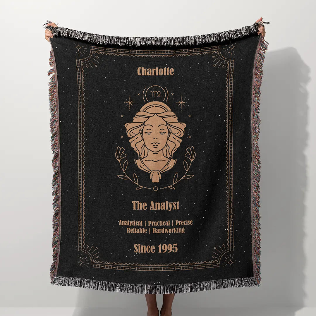 A custom blanket featuring a Virgo zodiac design held up on a white background, showcasing a personalized name, date, and traits.