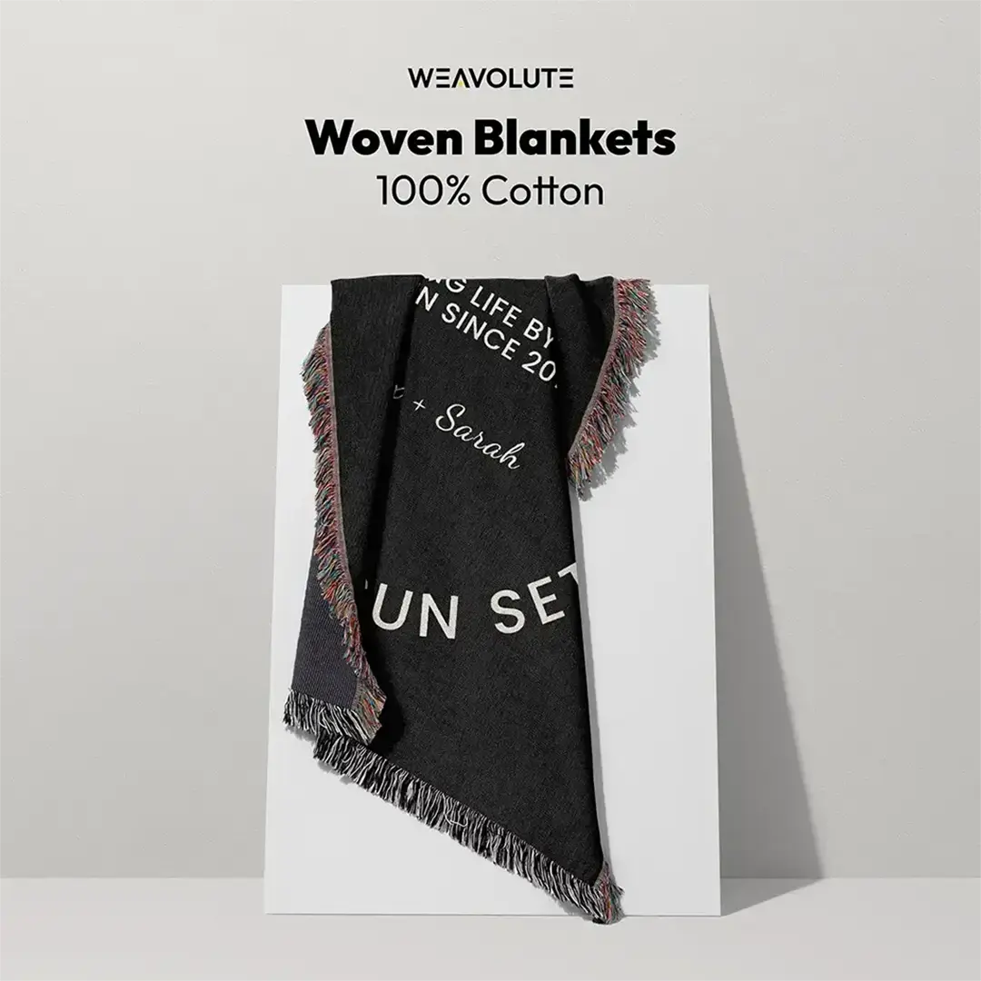 Black 100% cotton custom woven blanket with fringed edges displayed on a white board, featuring personalized text and the Weavolute logo above.