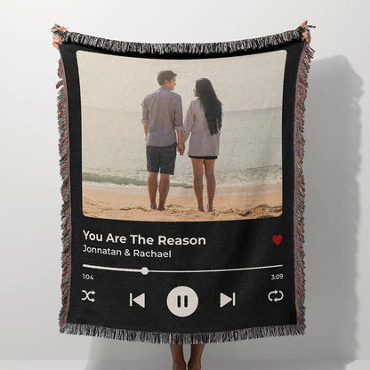 Personalized music player woven cotton blanket for couples, displayed outdoors, held up by a person in a natural green park setting.
