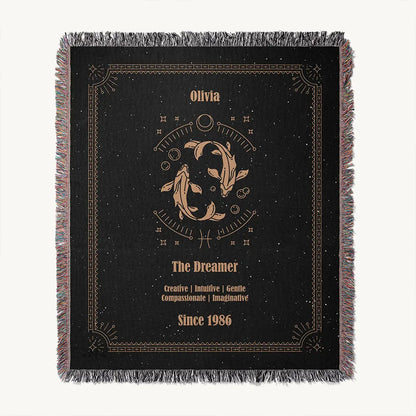 Flat lay of a Pisces zodiac custom woven cotton blanket on a white background. The artwork features two swimming fish in a circular cosmic layout, with custom texts.