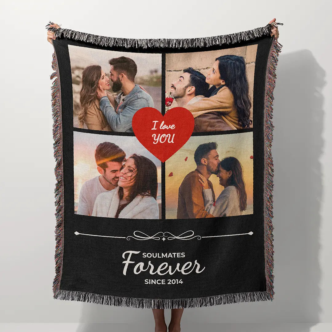 Personalized black woven photo cotton blanket for couples with fringed edges held outdoors against a blue sky and green trees.
