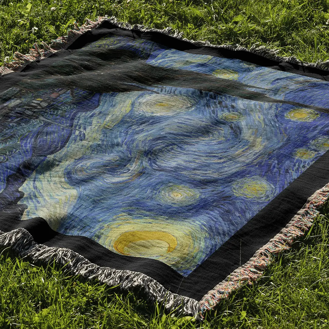 "The Starry Night" woven cotton blanket laid out on grass, highlighting the full composition of van Gogh’s famous painting with vivid stars and flowing brushstrokes.